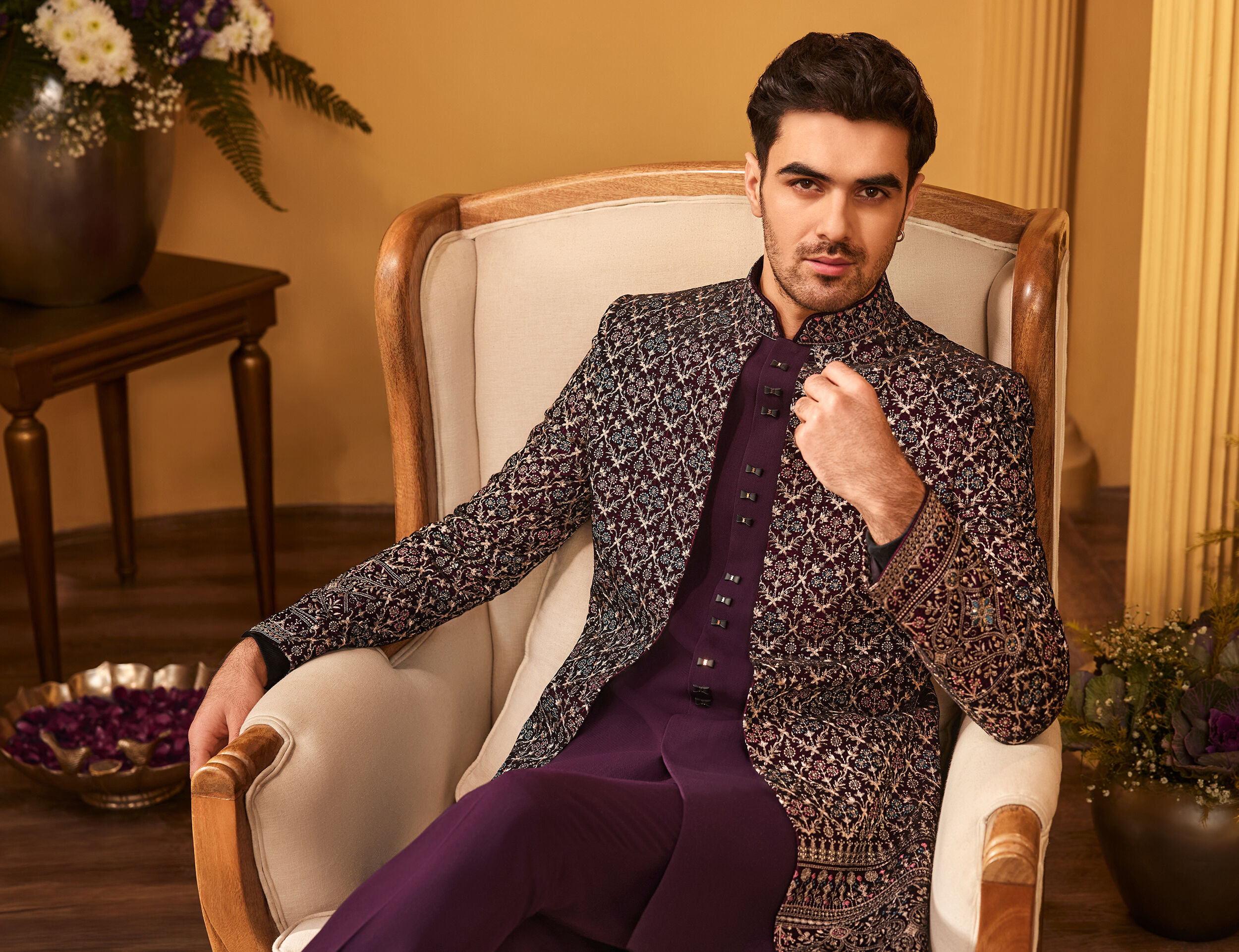 Men sitting on chair flaunting his elegant jodhpuri suit